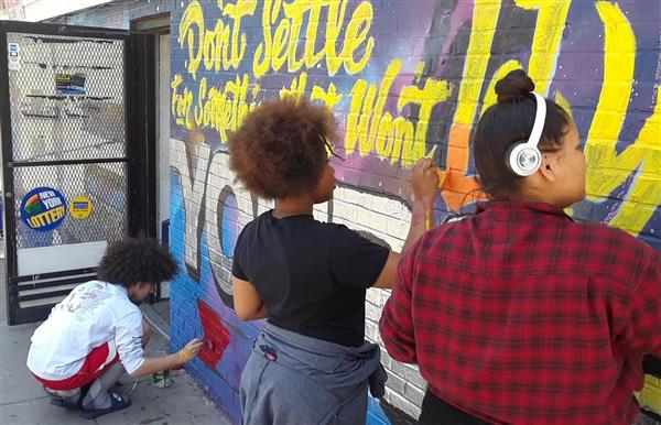 Students painting mural on local convenience store